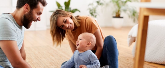 A family playing on the ground with their baby
